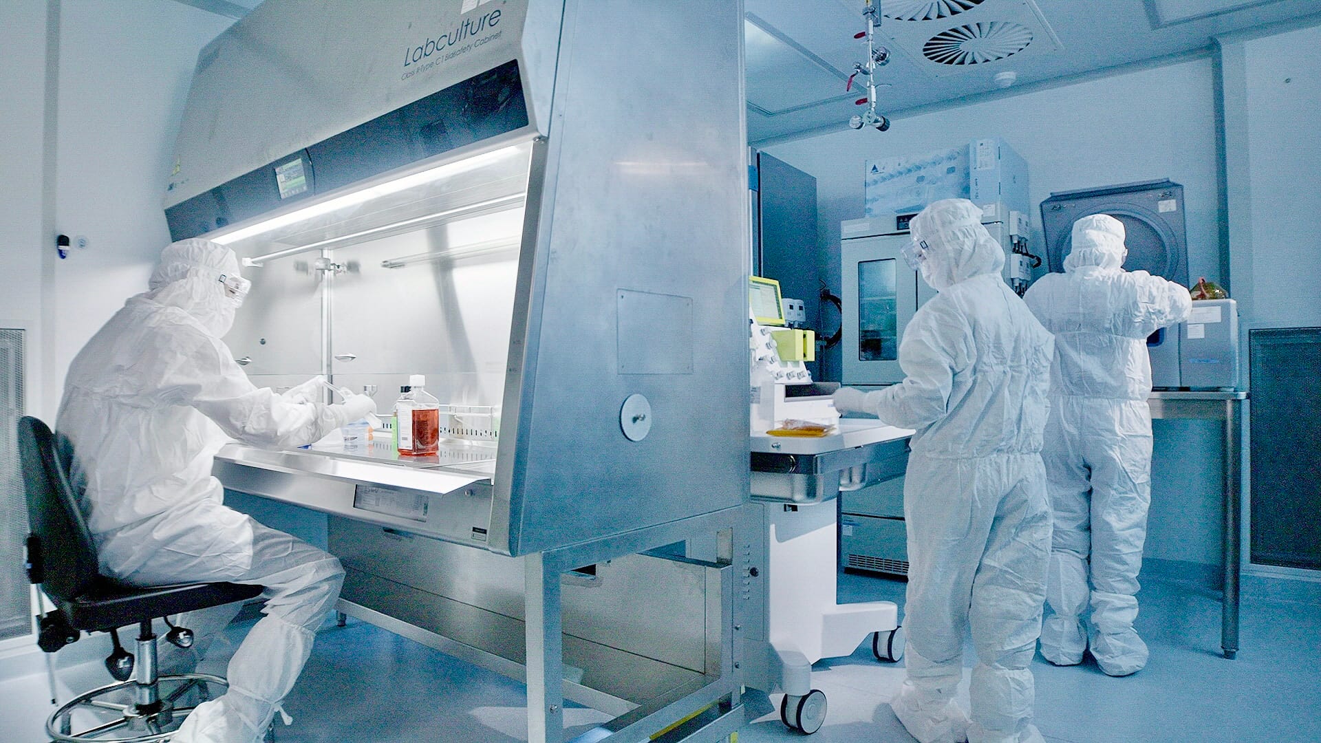 Three lab officers working on cell processing in a translational lab.